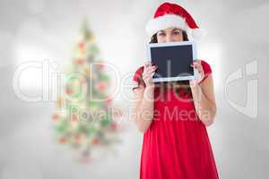 Composite image of festive brunette showing a tablet