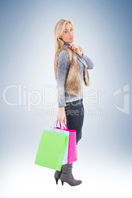 Blonde in winter clothes holding shopping bags