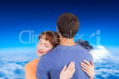 Composite image of happy couple hugging one another