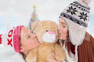 Composite image of mother and daughter kissing teddy