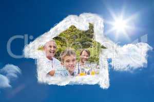 Composite image of laughing family having a barbecue in the park