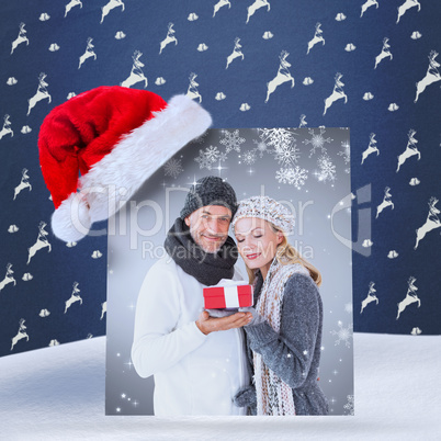 Composite image of happy winter couple with gift