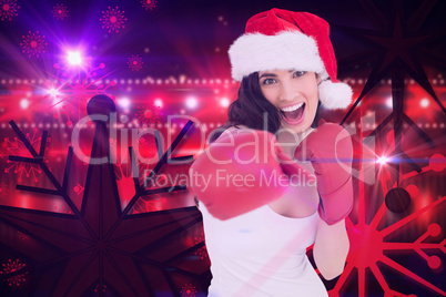 Composite image of festive brunette in boxing gloves punching