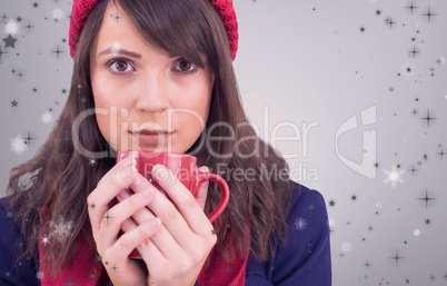 Composite image of serious young woman holding a mug