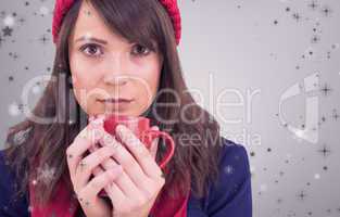 Composite image of serious young woman holding a mug