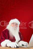 Composite image of santa surfs on the internet