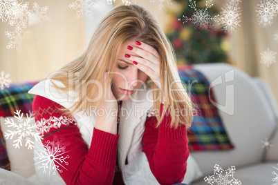 Composite image of sad woman sitting in the living room on a cou