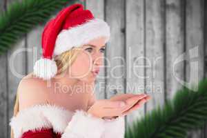 Composite image of festive blonde blowing over hands