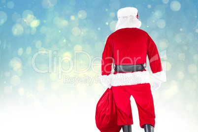 Composite image of rear view of santa claus holding a sack