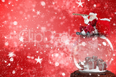 Composite image of santa sitting on snow globe