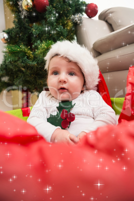 Composite image of cute baby boy in large christmas present