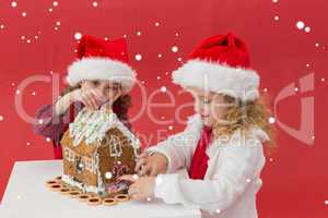 Composite image of festive little girls making a gingerbread hou