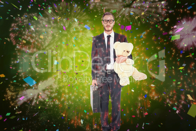 Composite image of geeky businessman holding briefcase and teddy