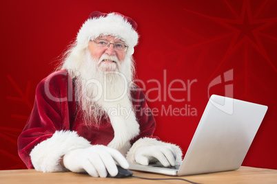 Composite image of santa surfs on the internet