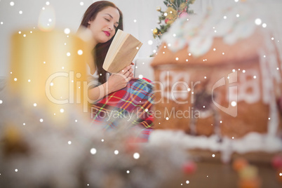 Composite image of peaceful brunette reading on the couch with c