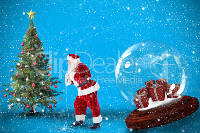 Composite image of santa pulling snow globe of presents