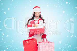 Composite image of surprised brunette in winter clothes holding