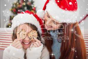 Composite image of festive mother and daughter on the couch with