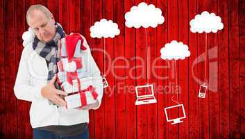 Composite image of festive man holding christmas gifts