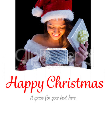 Composite image of pretty brunette in santa outfit opening gift