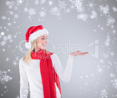 Composite image of festive blonde holding hand out