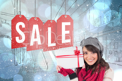 Composite image of festive brunette holding white and red gift