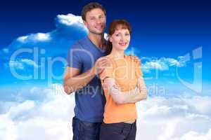 Composite image of happy couple looking at camera