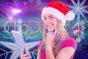 Composite image of festive blonde using tablet pc