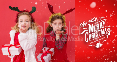 Composite image of festive little girls holding gifts