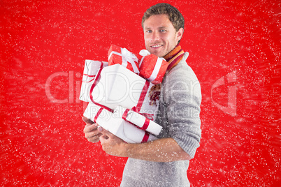 Composite image of man holding some large presents