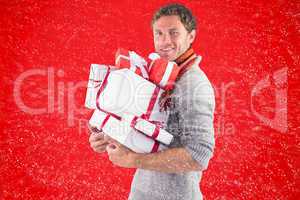 Composite image of man holding some large presents