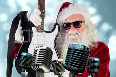 Composite image of father christmas shows a guitar