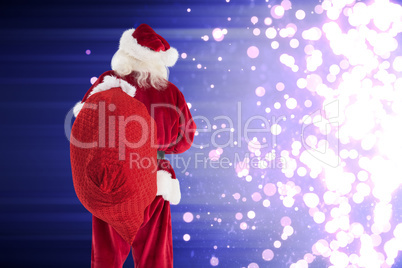 Composite image of santa is holding his bag in one hand