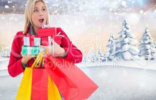 Composite image of festive blonde holding many gifts