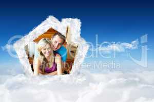 Composite image of happy couple sitting on floor handing a glass