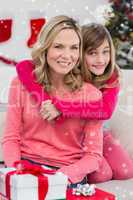 Composite image of festive mother and daughter smiling at camera