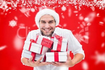 Composite image of festive man holding christmas gifts