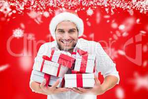 Composite image of festive man holding christmas gifts