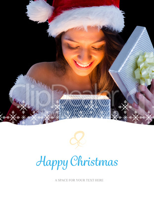 Composite image of pretty brunette in santa outfit opening gift