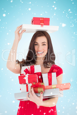 Composite image of smiling brunette holding many gifts