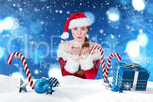 Composite image of pretty girl in santa costume blowing at camer