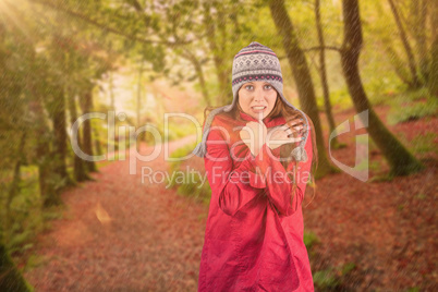 Composite image of cold redhead wearing coat and hat