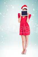 Composite image of festive brunette holding a tablet pc