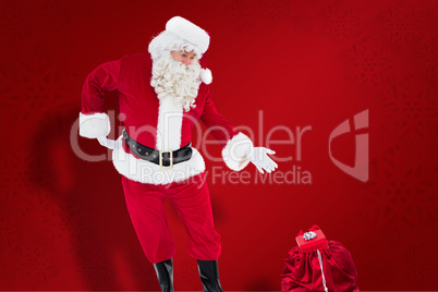 Composite image of santa claus showing sack full of gifts