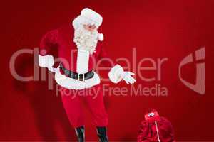 Composite image of santa claus showing sack full of gifts