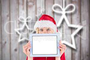 Composite image of festive blonde holding a tablet pc