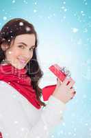 Composite image of smiling brunette opening christmas present