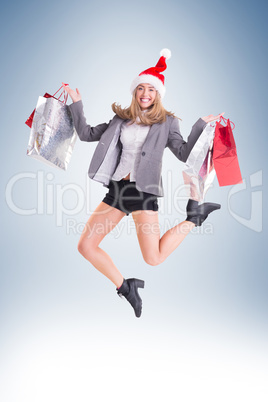 Festive blonde jumping with shopping bags