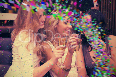 Composite image of happy friends drinking champagne together