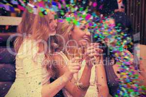 Composite image of happy friends drinking champagne together